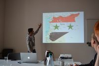Antoine Capucci vor einer Landkarte von Syrien